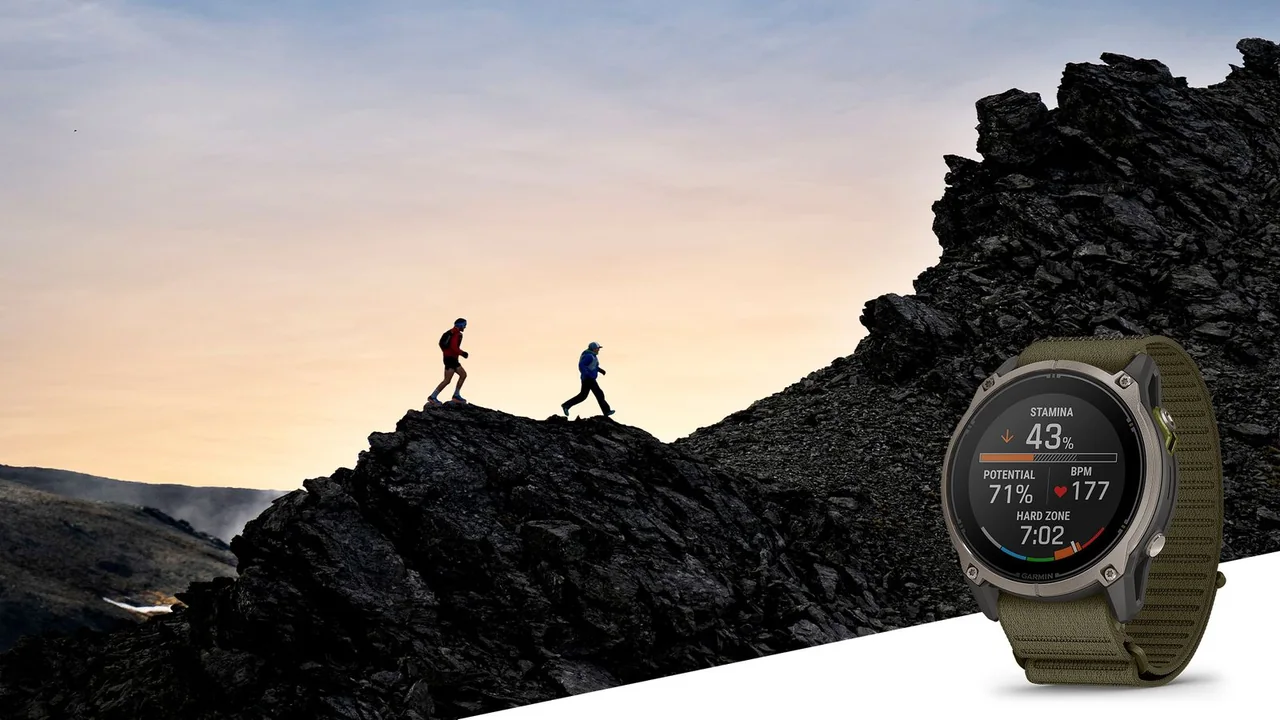 Zwei Trailrunner auf einem Felsgrat im Abendlicht, rechts im Vordergrund die Garmin Enduro 4 mit gr&uuml;nem Textilarmband