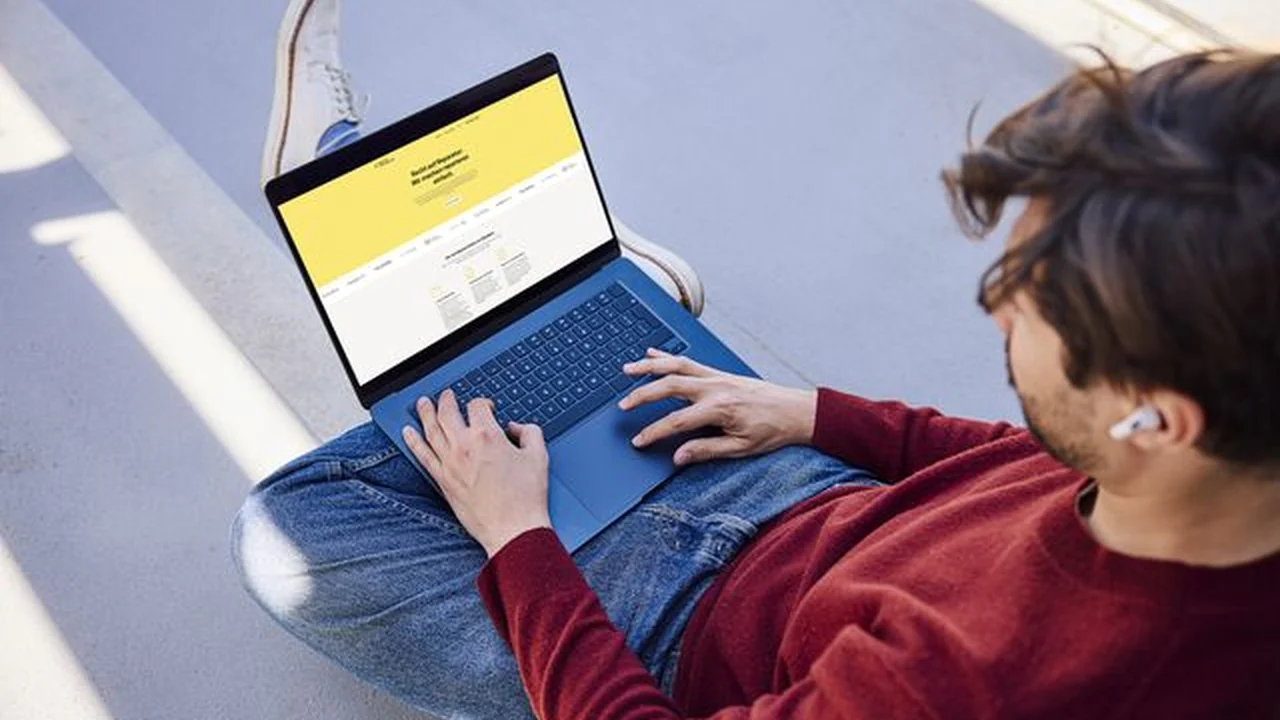 Person sitzt draußen mit Laptop und nutzt die Werkstattsuche der Reparaturplattform